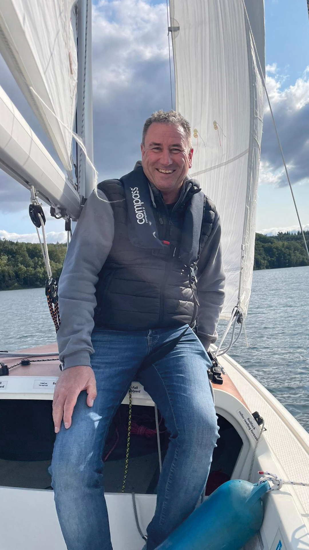 Jens Müller sitzt auf dem Dach eines Sportsegelboots.